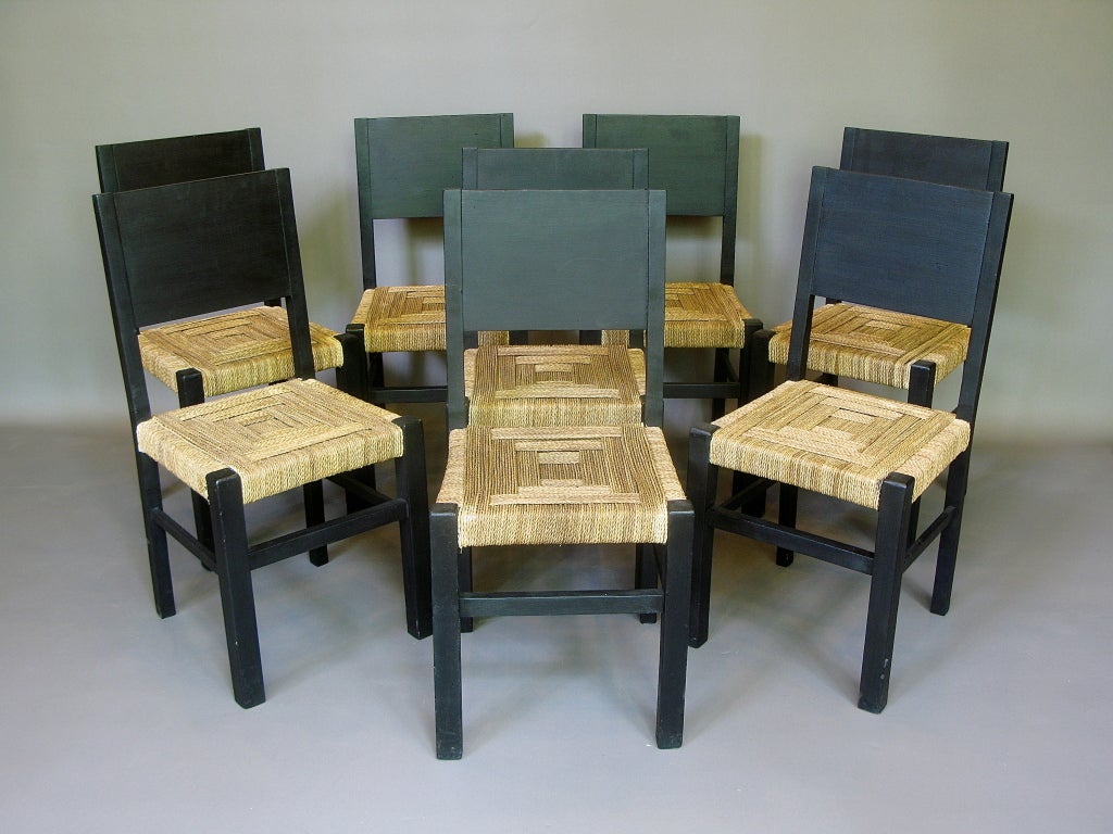 Very graphic and chic set of eight dining chairs of black painted wood and rush seats.

The simplicity of their structure and the geometric rush weave of the seats make them very similar to chairs by French designer Francis Jourdain, who was an