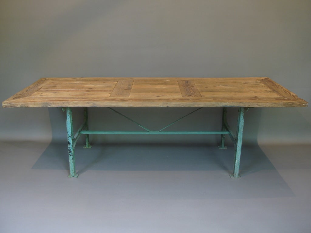 Cast iron base with green paint patina. Pine top.