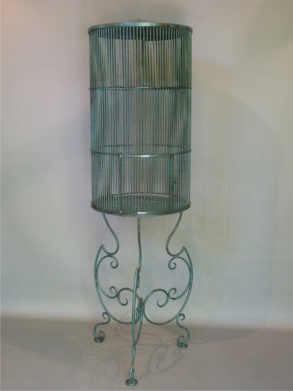 Very rare and elegant pair of cylindrical bird cages, painted green. Flamboyant, in a classical, Madeleine Castaing sort of way. Would look wonderful in a glassed winter garden!
Designed for parrots, the rods are very thick to prevent them cutting
