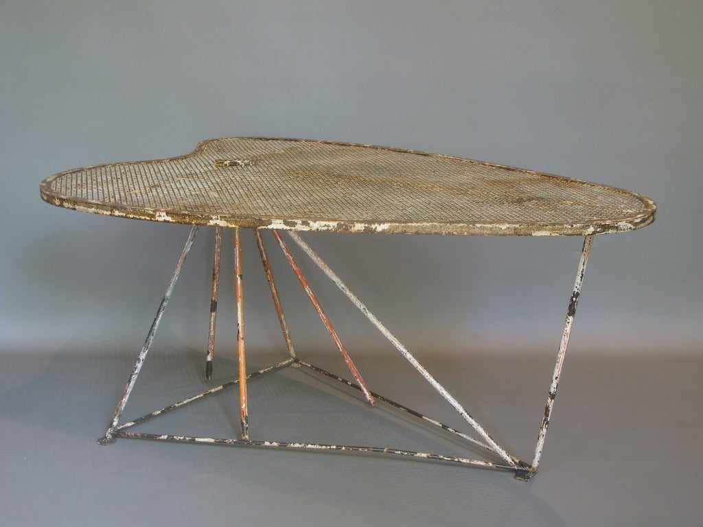 Unique and unusual dining table attributed to Mathieu Matégot. The top is shaped to resemble a painter's palette (or a heart) and is made made of sturdy-quality cloverleaf-patterned perforated sheet metal.

The top is supported by seven iron rods