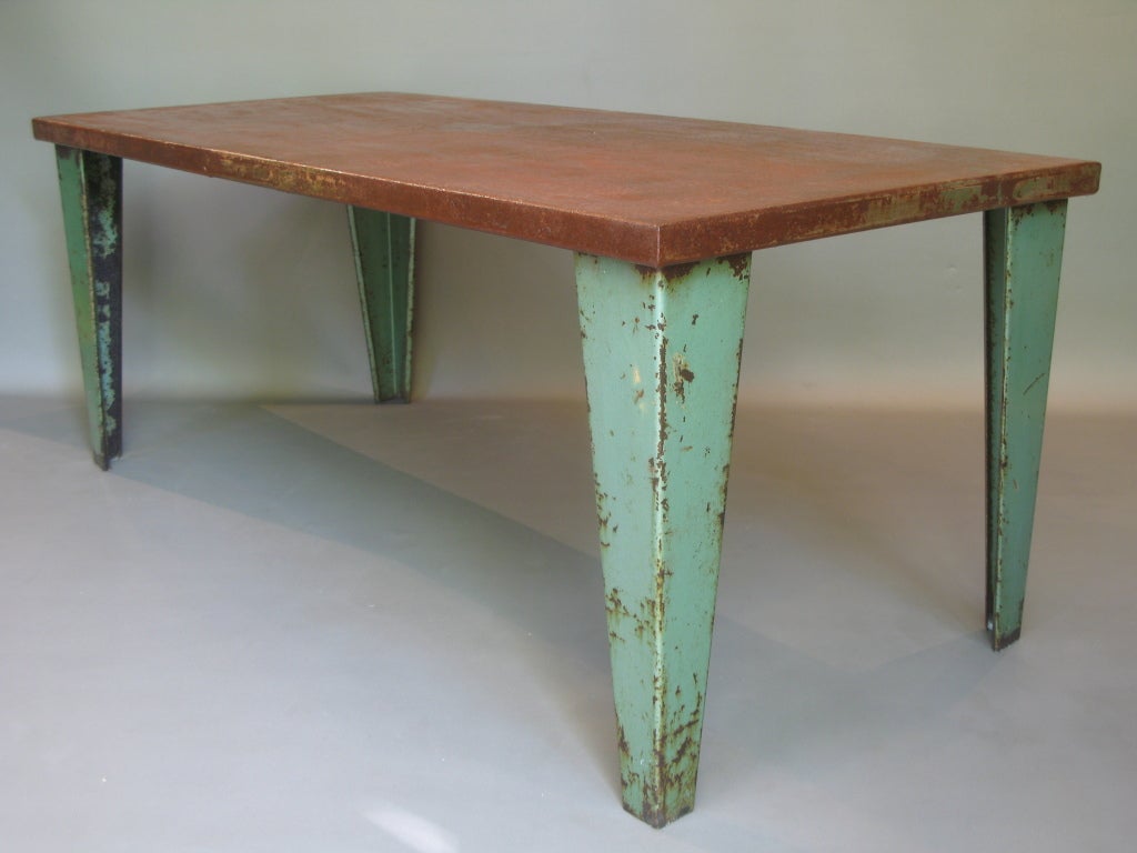 Industrial table made out of heavy, good quality bent sheet metal. 
Tapering legs.
Green paint on base and reddish-brown, rust-coloured top.