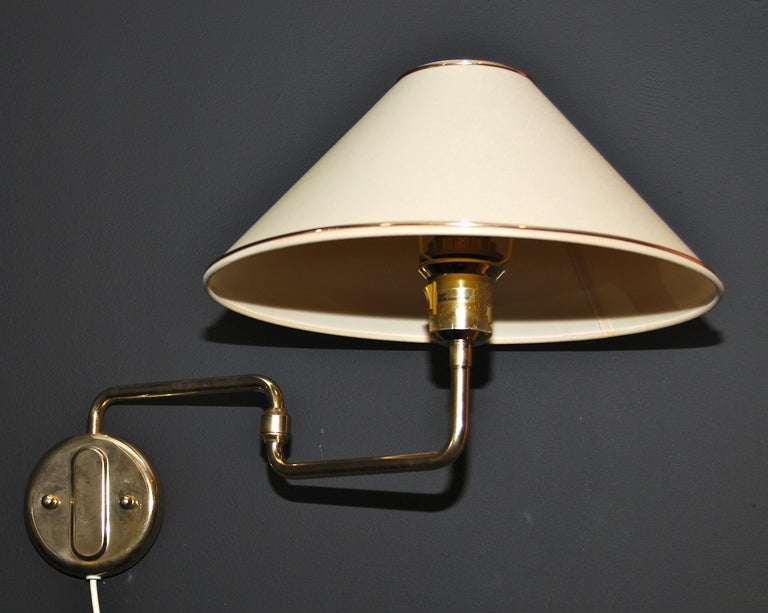 Mid 20th Century wall lighting fixture with adjustable swing arm.
Original fabric shade with brass trim.
Arm projection from 8