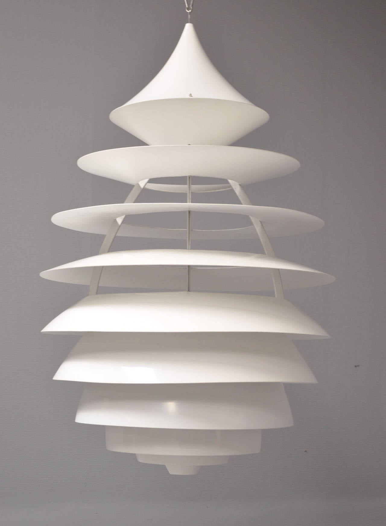 A pendant designed by Kurt Nørregaard for Louis Poulsen. The model 'LP Centrum' designed in 1990 based on Poul Henningsen sketches, inspired by the lituus curve. White-varnished aluminium, ten shades. 
H. approximate (107 cm,) 42