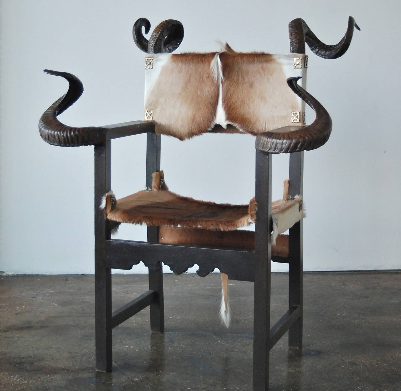 Ein Stuhl von Gernot Rasenberger. Spanien, gegen Ende des 20. Jahrhunderts.
Bemaltes Holz, Kuhfell und Hörner mit Messingverzierung.
Etikett: 