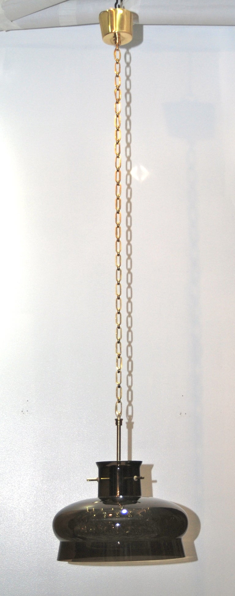 Glass pendant by Carl Fagerlund fro Orrefors, Sweden.
Double glass shades on brass chain. Orrefors labelled.
Drop with a chain 53