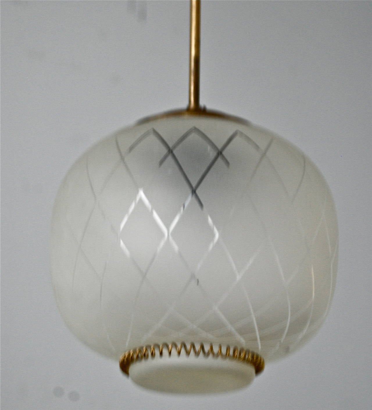 A pendant, probably by Orrefors, Sweden, circa late 1930s.
Body in brass, shade of frosted glass with etched decoration. dimensions: Height 9