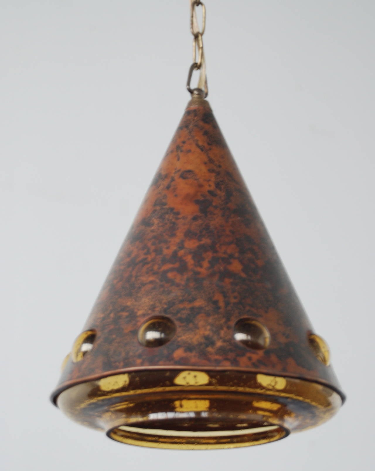 A pendant designed by Nanny Still McKinney for RAAK, Netherlands, circa 1960s. Solid amber glass cone with patinated copper cower.
Small crack inside the glass shade. Dimensions: H 13