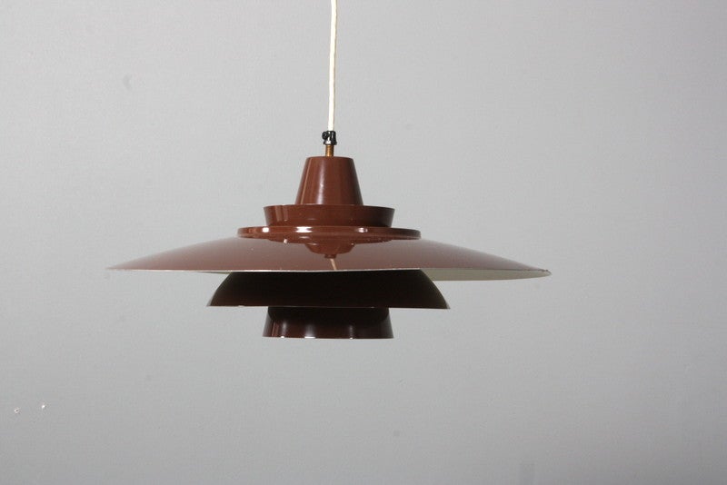 A pendant of brown lacquered metal. Measure: Ø 20