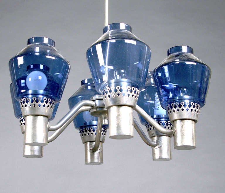 Chandelier designed by Hans-Agne Jakobsson, Swden
Frame in nickel plated metal, light arms finished with shades of bluish glass. Measures: Height 80 cm, (32