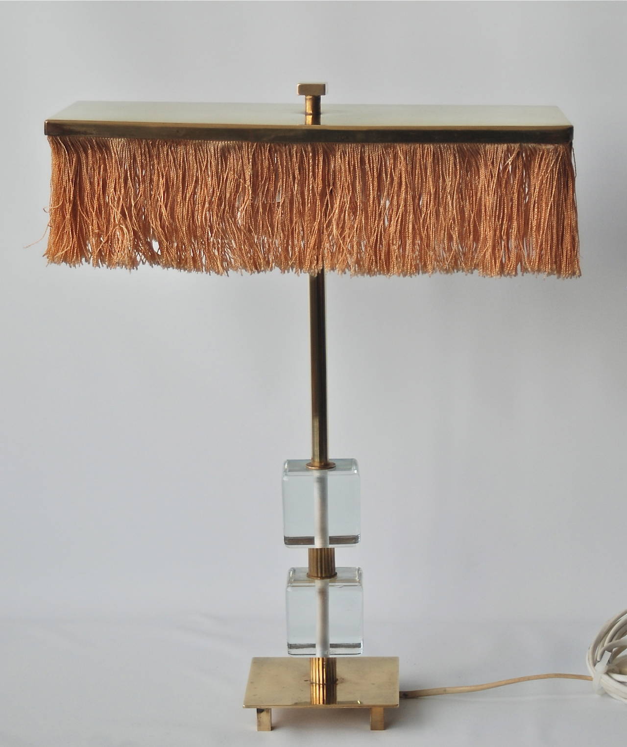 A table lamp made by Malmo Mettalyarufabrik AB, Sweden, circa 1960.
Clear glass and brass. Original shade. Measures: H 17"; base 4.5" x 4.5"; cubes 2.5" x 2.5". The shade 13.75" x 6" x 4" H.
 Existing