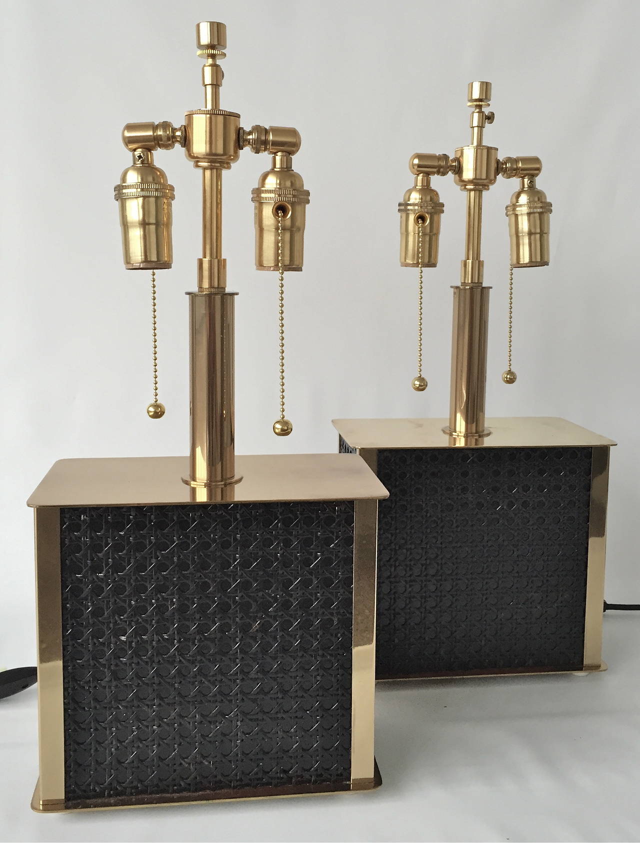 A pair of Swedish table lamps, circa mid-20th century.
 Marked: Bergboms B-55.
Black caned base with polished brass accents.
Newly rewired with black silk cord and matching hardware with adjustable height stem. Measure: Base 8.75