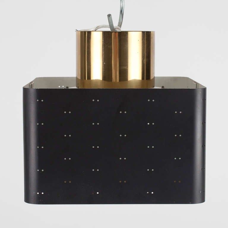 A pendant designed by Paavo Tynell for Idman, Finland.
Lacquered perforated metal with brass grille and frosted glass panel. Stamped by manufacturer. Dimension: 9.5