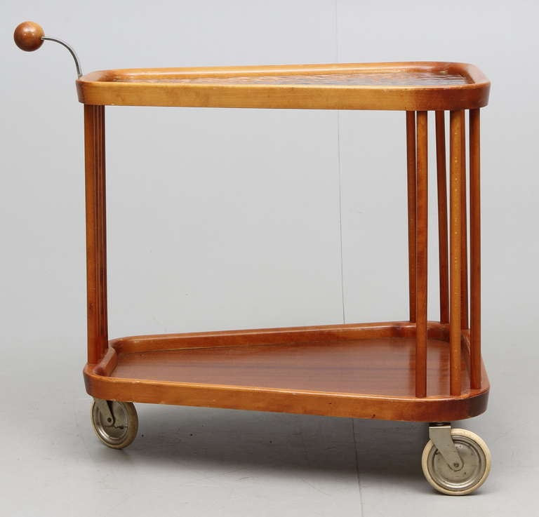A bar cart, design attributed to Axel Larsson for Bodafors, Sweden, circa 1940s.
Original casters and wood finish. The glass is later addition.
