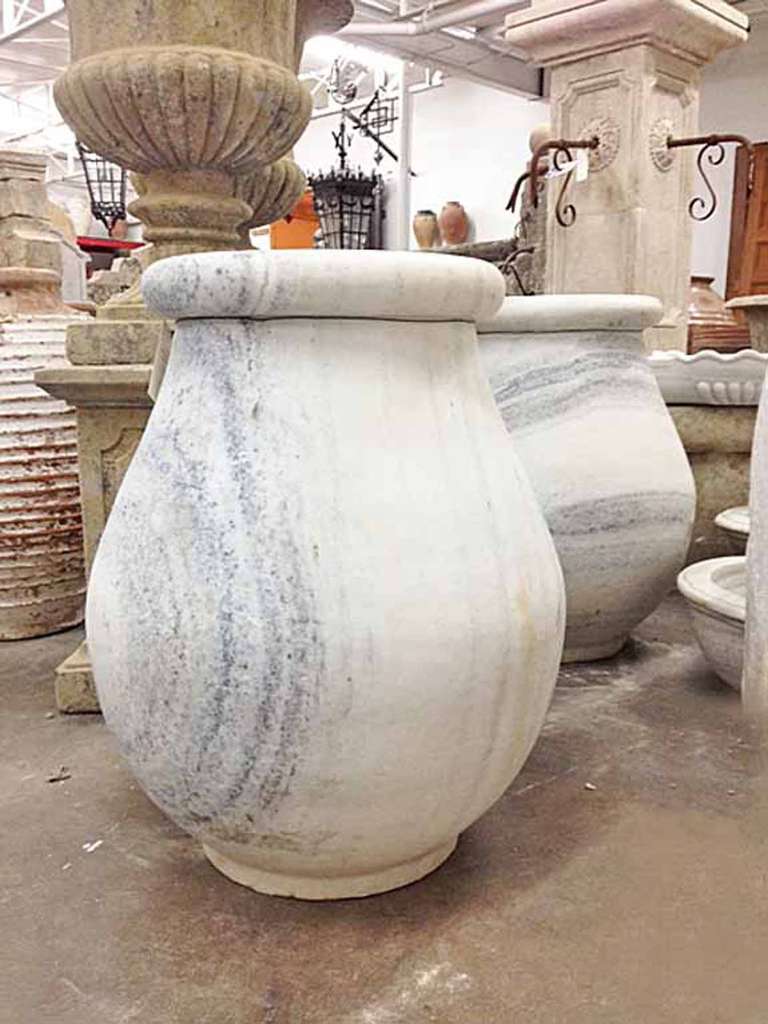 Very unique pair of white Carrara marble urns.