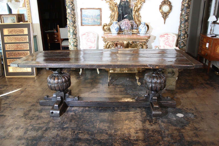 An Antique Oak and Elm wood console with massive hand carved buns supporting thick plank top with consistent gorgeous patina circa late seventeenth century. See additional photos on dealers website.