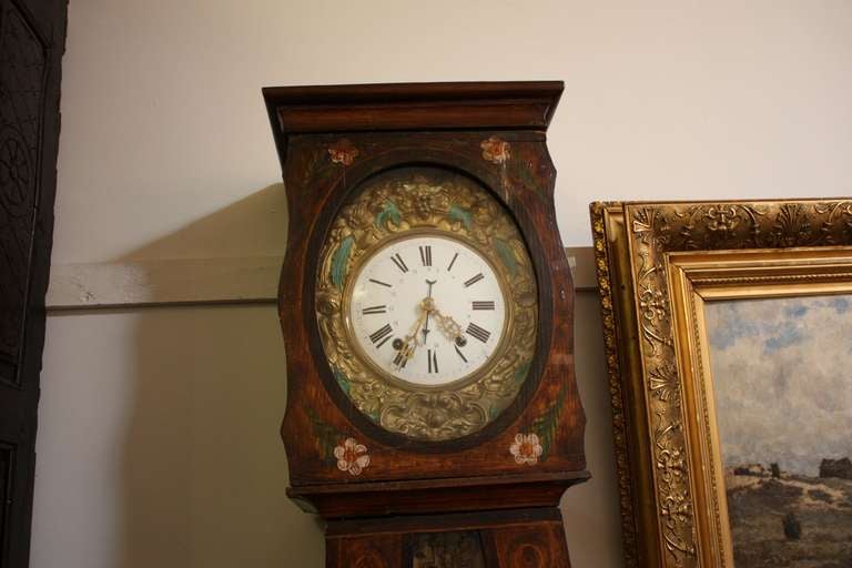 Early nineteenth century hand painted Swiss clock with embossed painted pendulum and face. In good working order. 