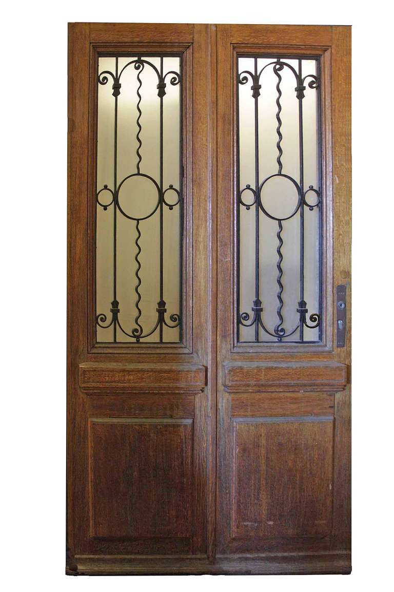 Impressive French antique oak door with ironwork. Interior-opening window panels allow cool breeze through during those beautiful days, without sacrificing security or privacy.