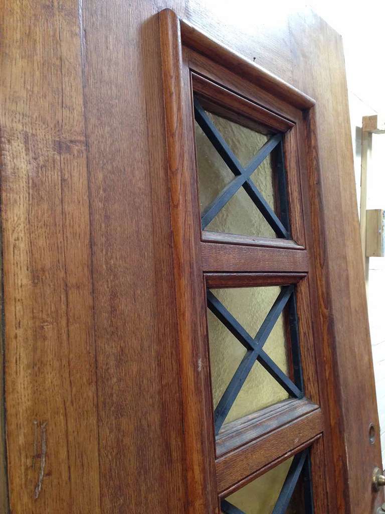 This antique French oak door has yellow textured glass windows with 