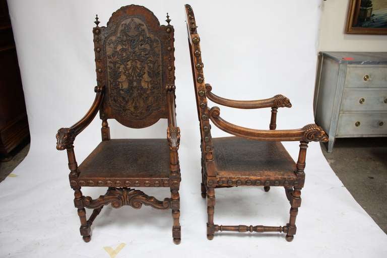 A nineteenth century pair of Walnut and tooled leather armchairs with bronze accents from Portugal. These chairs feature detailed rams head carvings and have a great patina.