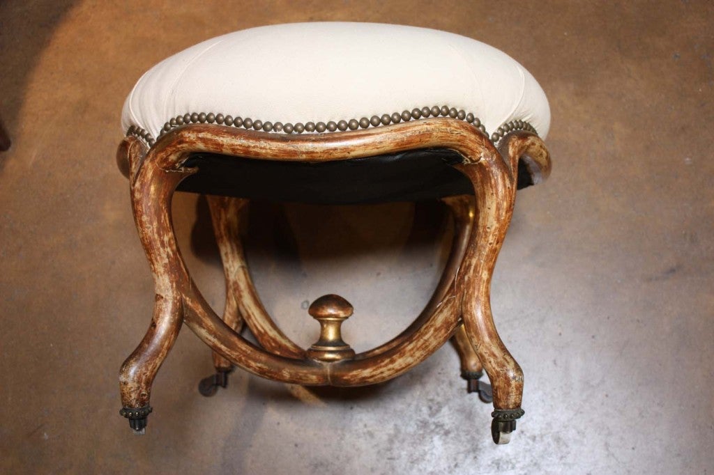 A fun shabby chic French art nouveau ottoman with polychrome finish. This was originally water gilt and has been worn down to primarily bole and gesso.