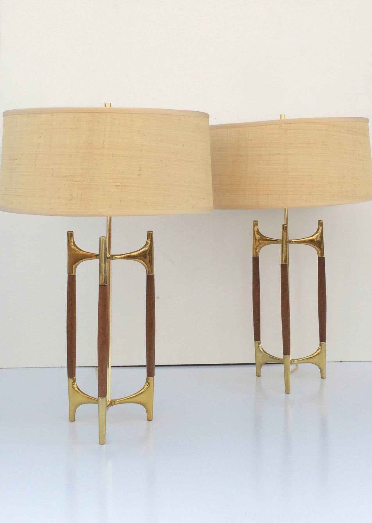 A pair of brass and walnut table lamps designed by Gerald Thurston and made by Lightolier, circa 1950s.
Newly rewired with new custom-made shades.