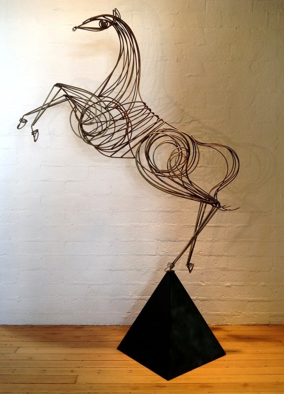 This amazing metal sculpture stands over six feet tall. It insets into a black metal base that has been repainted.  Is signed on the horse and the inside of the base 