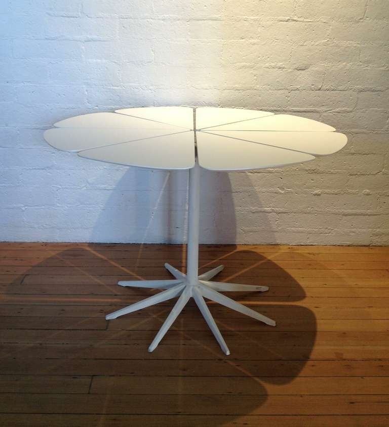 A petal dining table by Richard Schultz for Knoll
This table consist of a eight white painted wood pieces,cut to look like flower petals that attach to painted white aluminum base.
