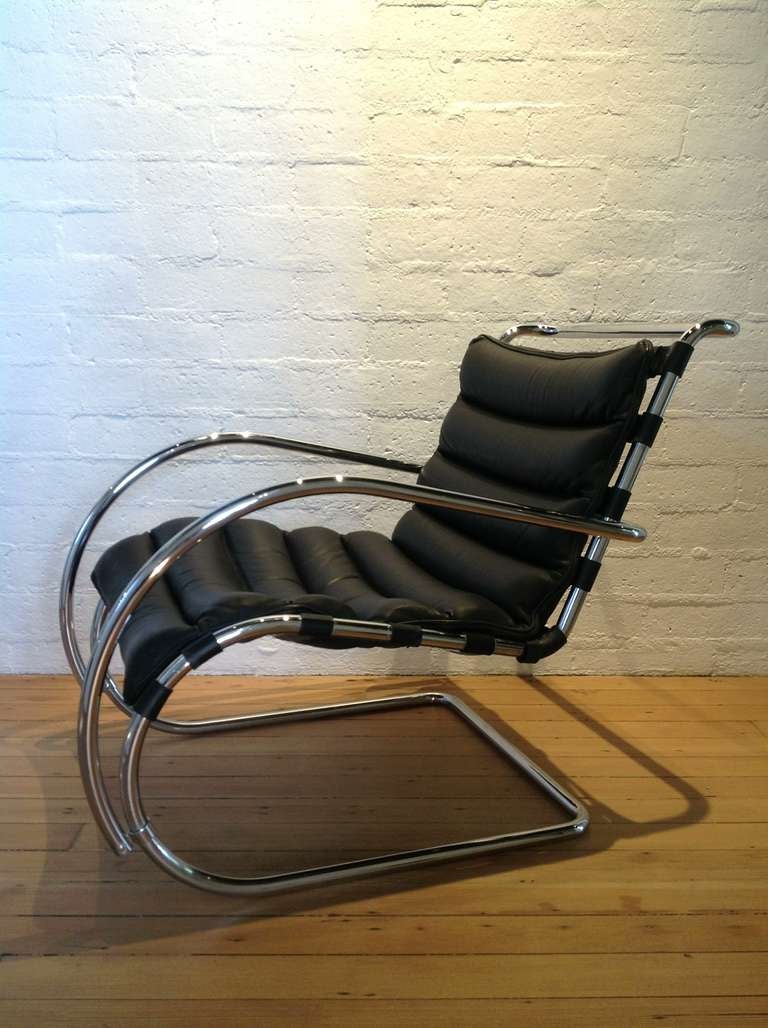 A pair of Mies Van Der Rohe MR lounge chairs made by Knoll.
These chairs have a chrome base with leather straps that support the black leather cushion.