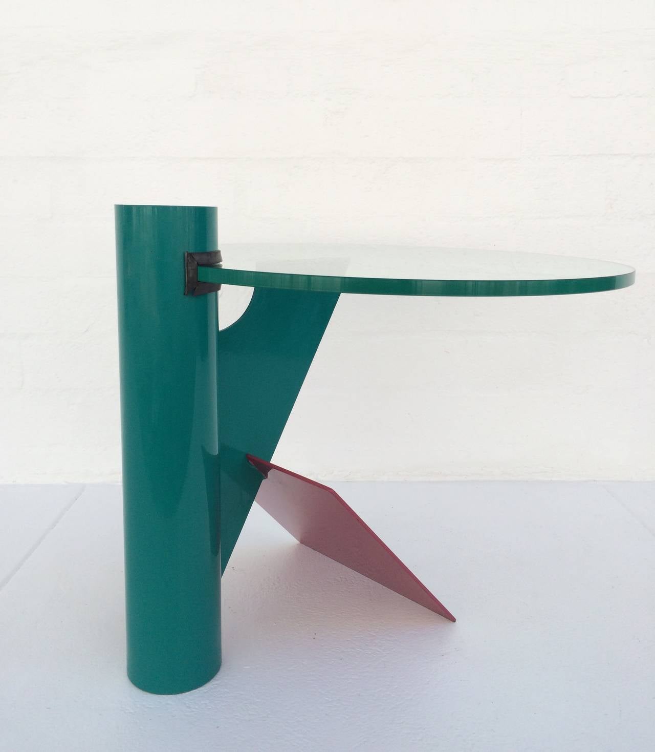Une table d'appoint amusante et fantaisiste de style Memphis, à la manière de Peter Shire. 
Cette table est composée d'acier peint et d'un plateau en verre de 23,5 pouces de diamètre et de 1/2 pouce d'épaisseur, 
vers les années 1980.