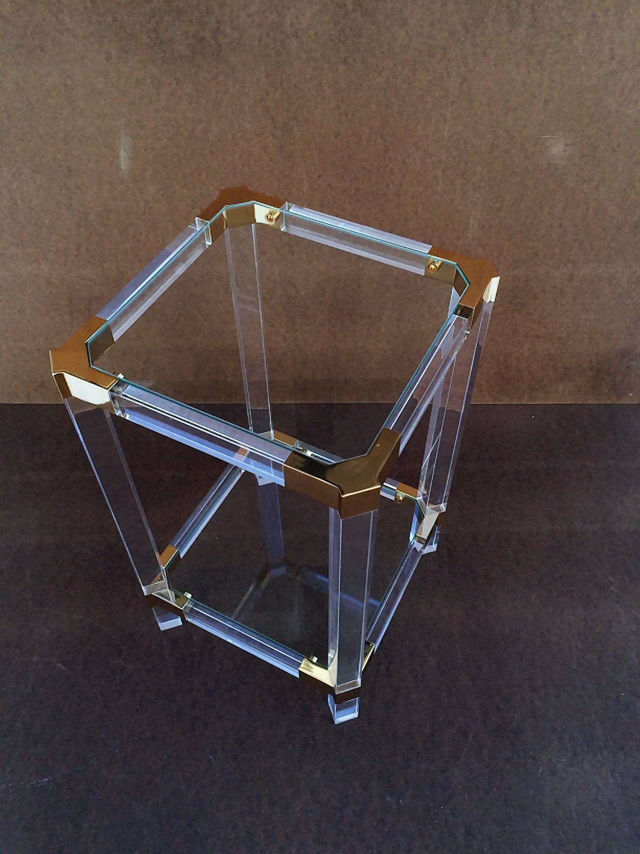 An acrylic and glass side table designed by Charles Hollis Jones. 
Consist of acrylic legs and frame supported together by brass corner pieces at the top and bottom with inset glass, 
circa 1980s.