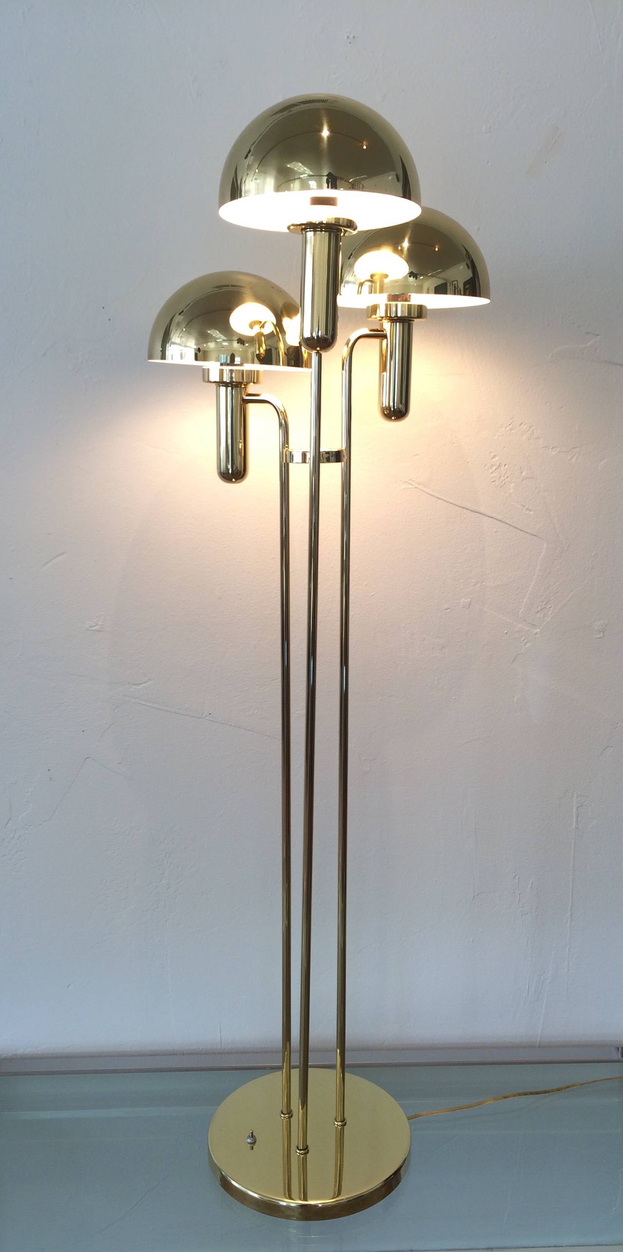This newly rewired vintage polished brass floor lamp is in the style of Verner Panton. 
Three different height brass rods each have a socket that takes a normal lightbulb. 
Each lightbulb then supports a polished brass light shade to complete this