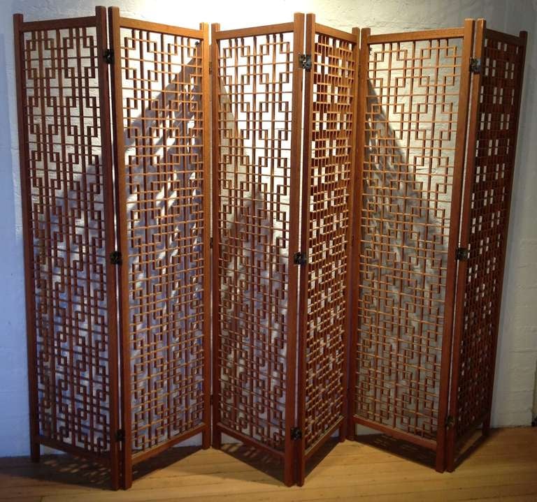 Stunning 6-panel teak, Mid Century Modern room divider screen. This piece is in excellent condition. The complex  and intricate geometric  pattern is created simply through masterful craftsmanship, with the placement of each piece of delicately cut