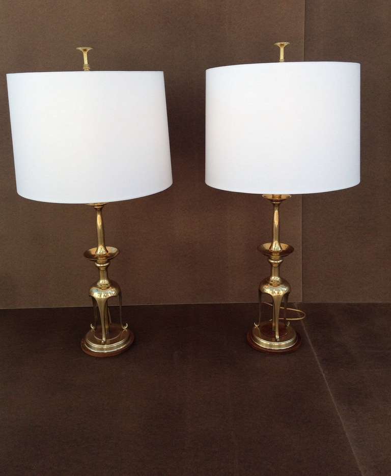 A pair of table lamps by Chapman. 
These sculptural lamps are solid brass with oak at the base. 
Retains the paper labels and are dated 1987
New white linen shades