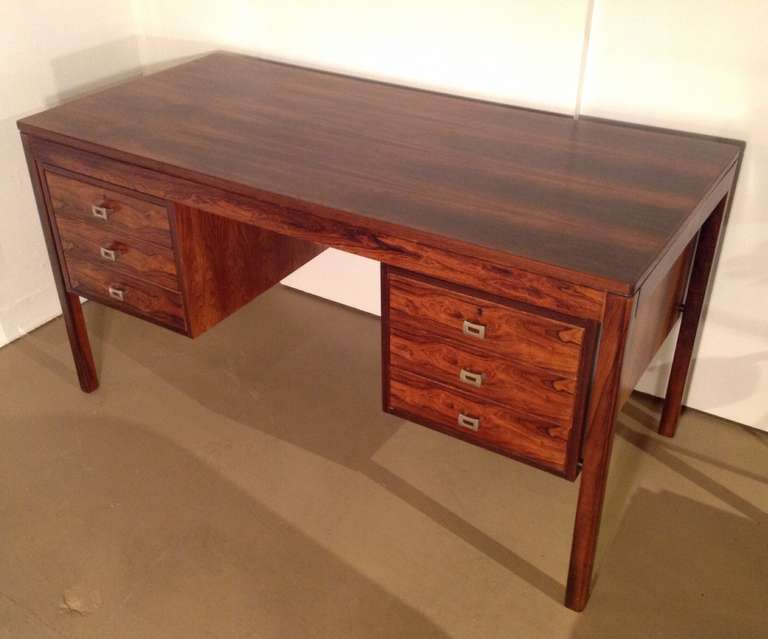 A 1960s rosewood desk with three drawers on the left side and one large file drawer on the right side.  
This desk is a beautiful rich rosewood with simple clean lines.