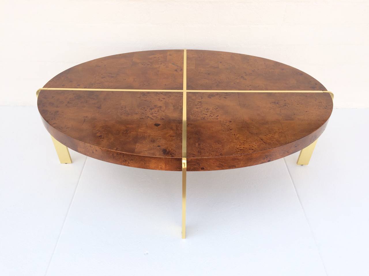 A beautiful burl wood top coffee or cocktail table with a heavy brass frame.
Four sections of burl wood make up the oval top, with the brass creating a nice dramatic presentation.
circa 1970s.