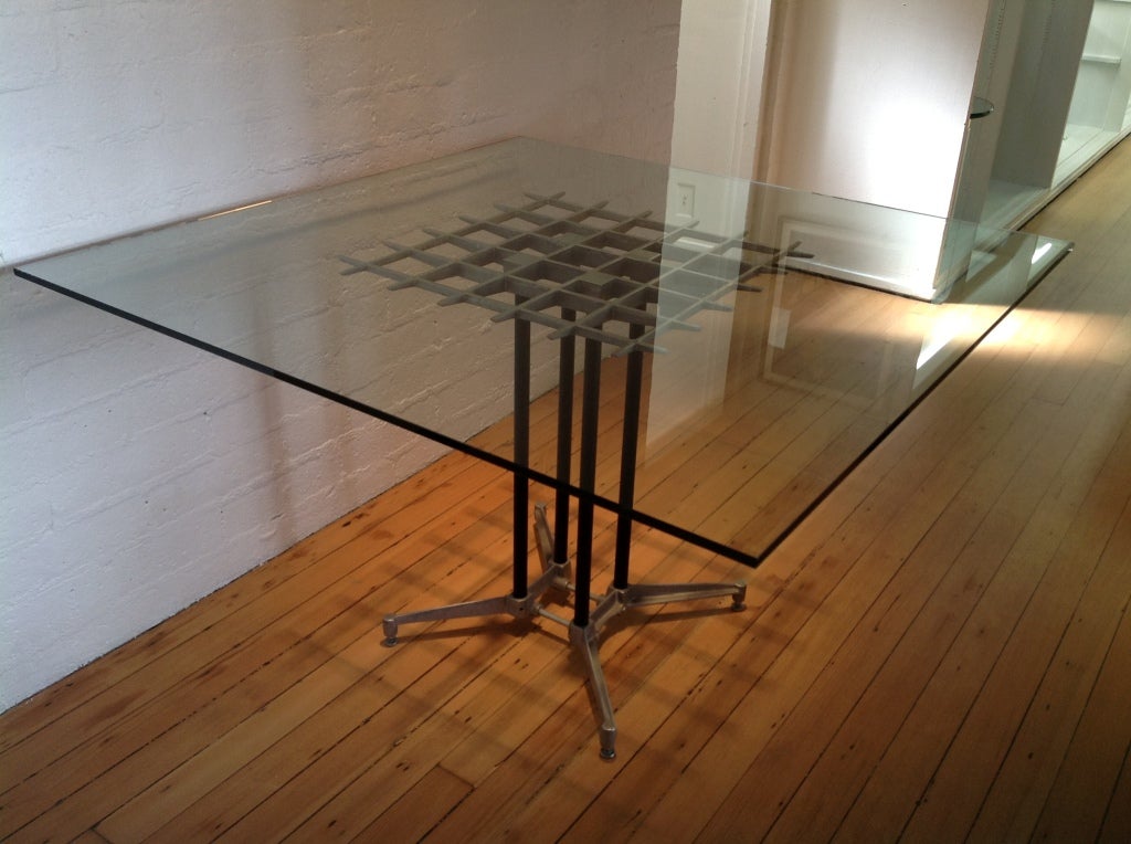 Description: A aluminum grid table by Robert Josten.
This table has an all aluminum base, with a grid pattern top,four black painted support legs that connect to a aluminum feet support base. The newly cut 1/2 inch glass top is 48