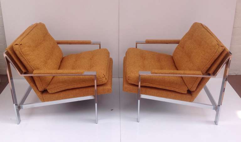 A pair of newly reupholstered in a burnt orange fabric with polished chrome base lounge chairs designed by Cy Mann Circa 1970s.