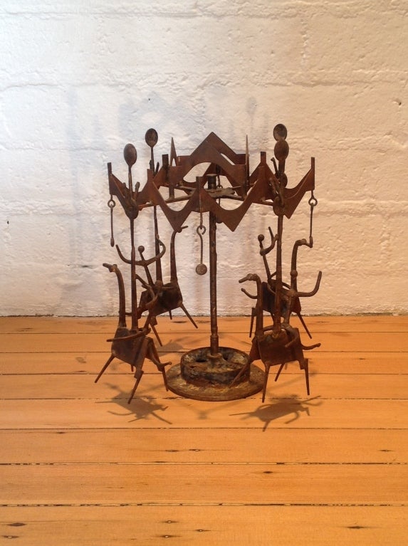 A metal sculpture of a Merry Go Round with four removable horse and rider figures by artist Henry Bursztynowicz ( American 1922-2001) This fun sculpture spins around.