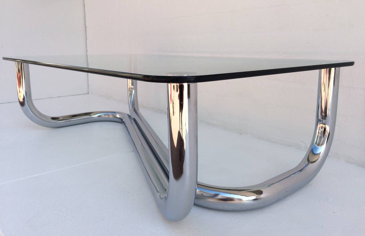 A sculptural 1960s polished chrome and glass coffee or cocktail table. 
Consist of two polished chrome tubes welded together to support the glass top. 
1/2