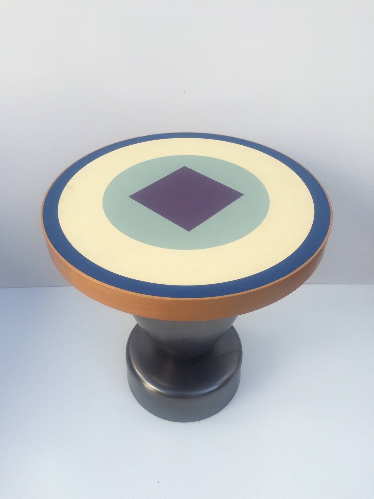 A wonderful side table designed by Ettore Sottsass for Zanotta, circa 1990s.
Consist of a ceramic base with a colorful laminate and wood top. 
Made in Italy. 
Excellent condition.