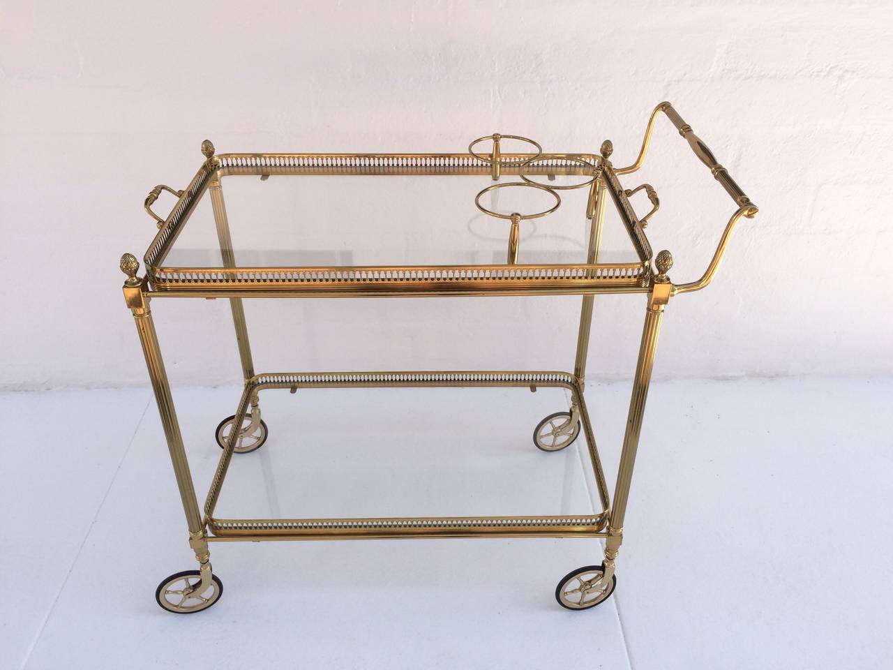 A very attractive 1960s French bar cart.
Solid polished brass with a removable top serving tray that has holders for three bottles.
Wheels are brass with black rubber tread for easy movement.