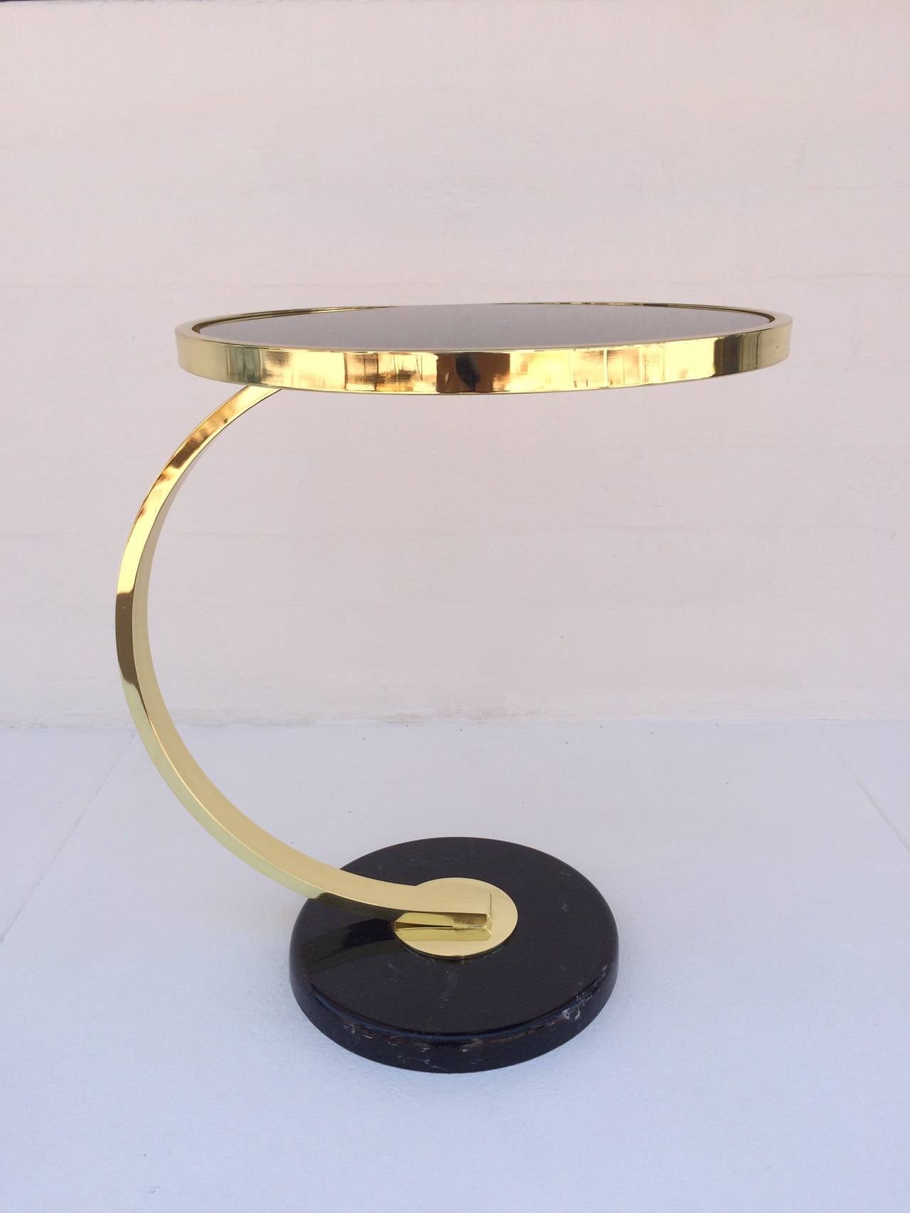This elegant side table designed by Milo Baughman for Design Institute of America is polished brass with black inset glass and a polished faux marble base.