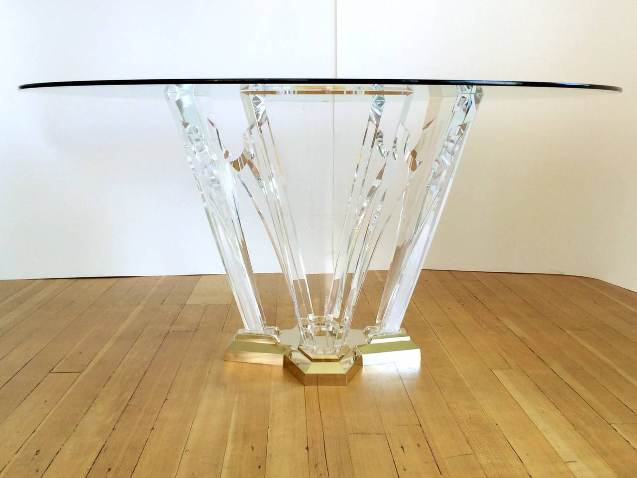 A gorgeous dining table by Spectrum Limited, signed and dated 1987. 
This table consist of a polished brass base that supports four sculptural acrylic pieces with a 59.5