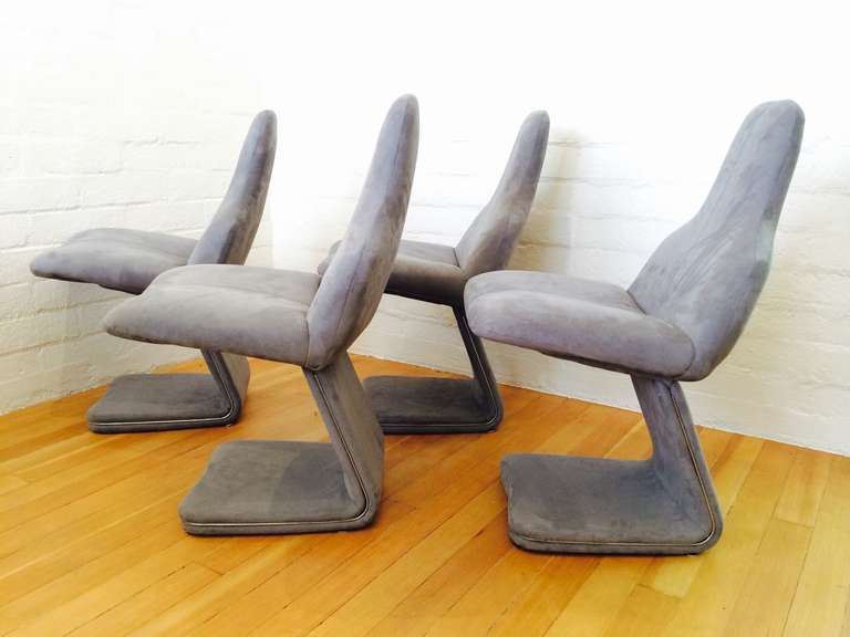 A set of four very chic dining chairs from the 1970s. 
Designed by Gastone Rinaldi for Rima. 
Newly reupholster in a gray Ultra-suede fabric.
