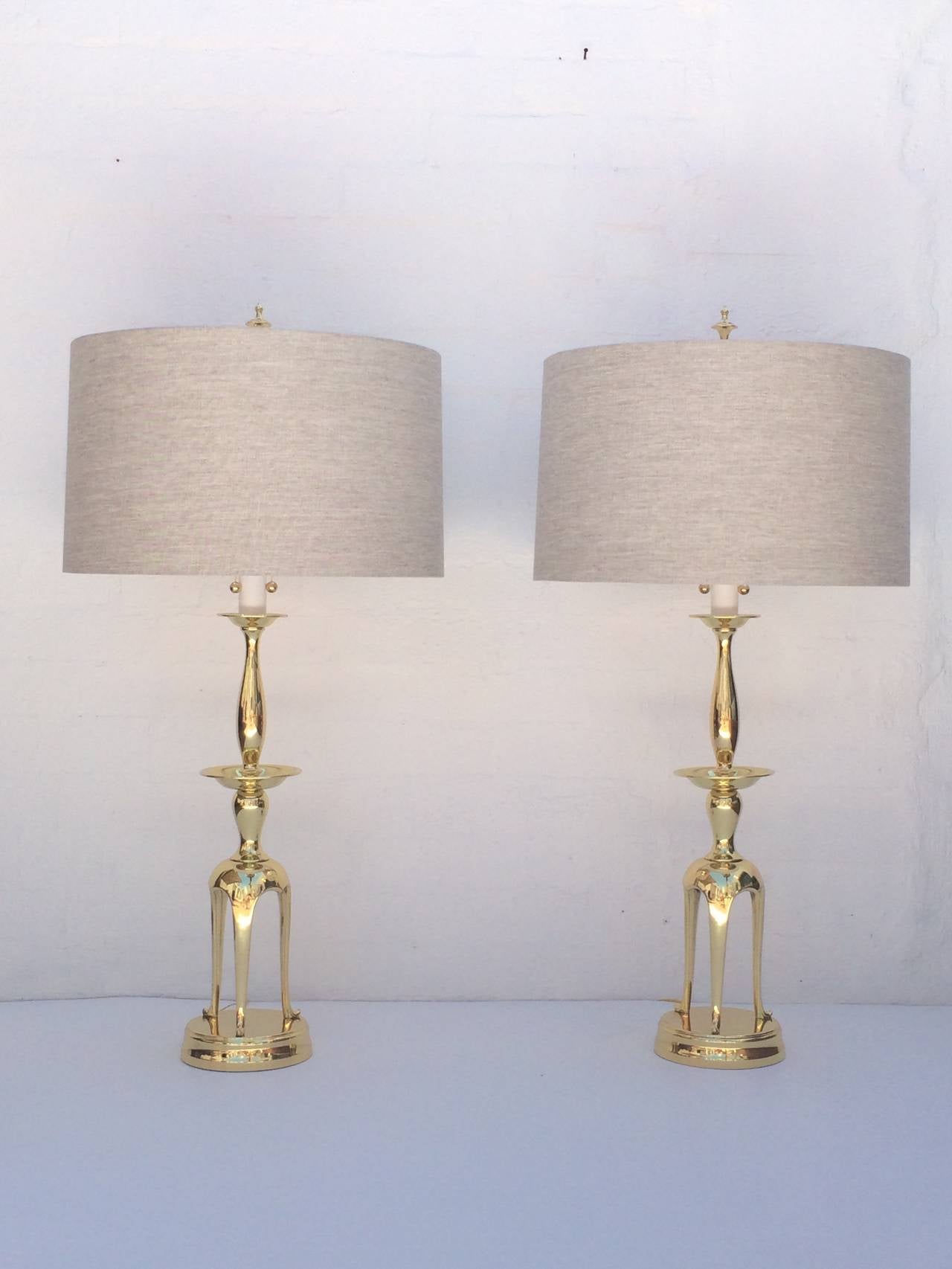 A stunning pair of tall table polished brass lamps made by Chapman in the manner of James Mont. 
Newly rewired, with new oatmeal colored linen shades, 
circa 1960s.