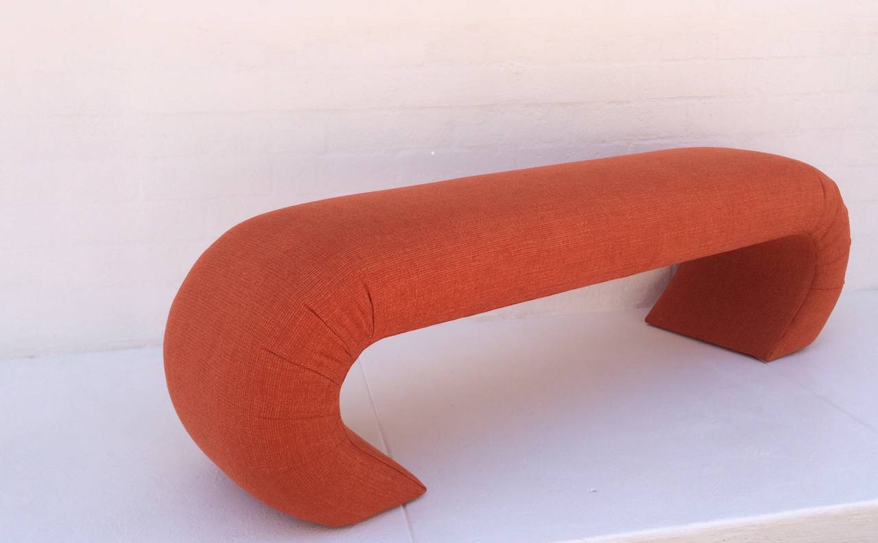A newly reupholstered bench in the manner of Karl Springer.
This bench was made for Steve Chase. 
This attractive bench has been recovered in a orange nubby cotton fabric with hints of gold.