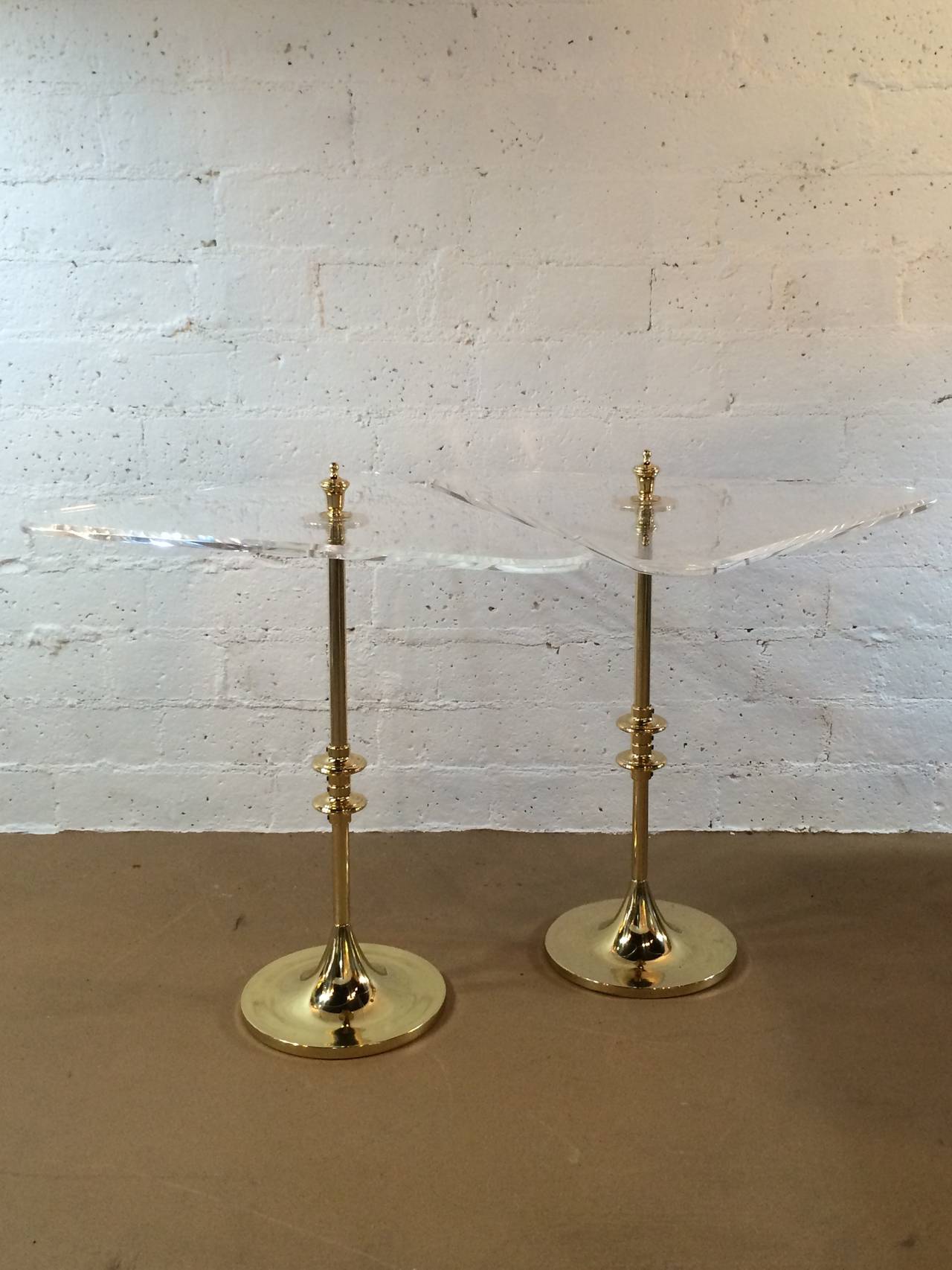 A pair of solid polished brass side tables with triangular 1/2 inch thick beveled acrylic tops.