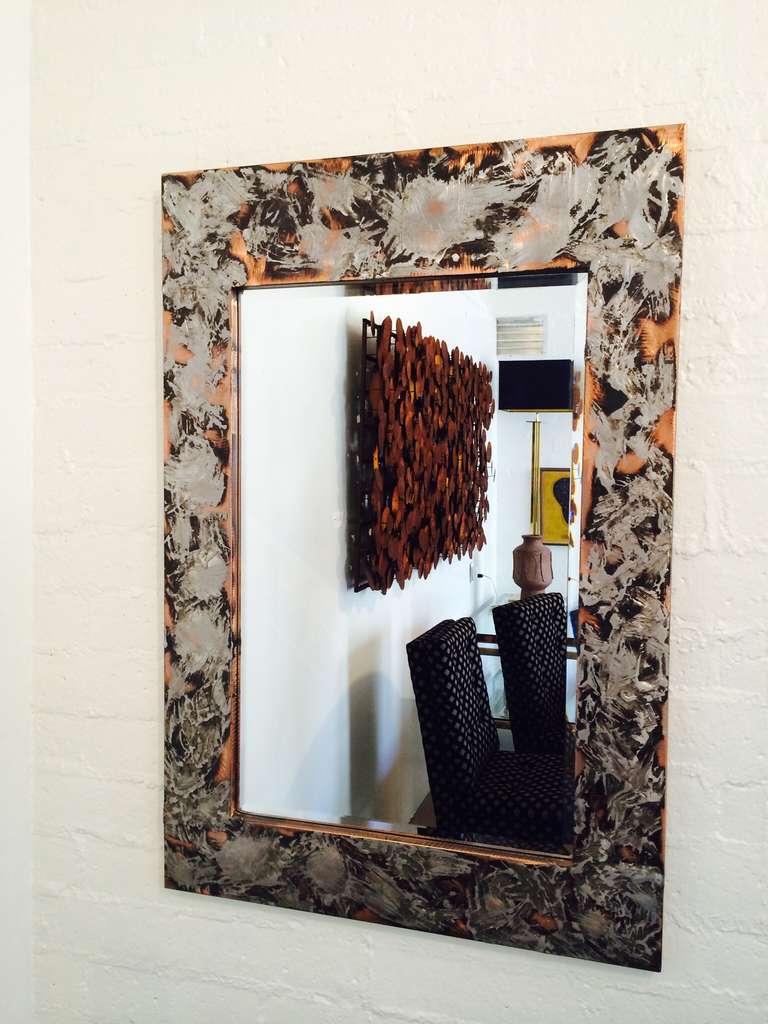 This gorgeous beveled mirror is a mixture of aluminum over copper.
Made by Autumn Guild circa 1980s