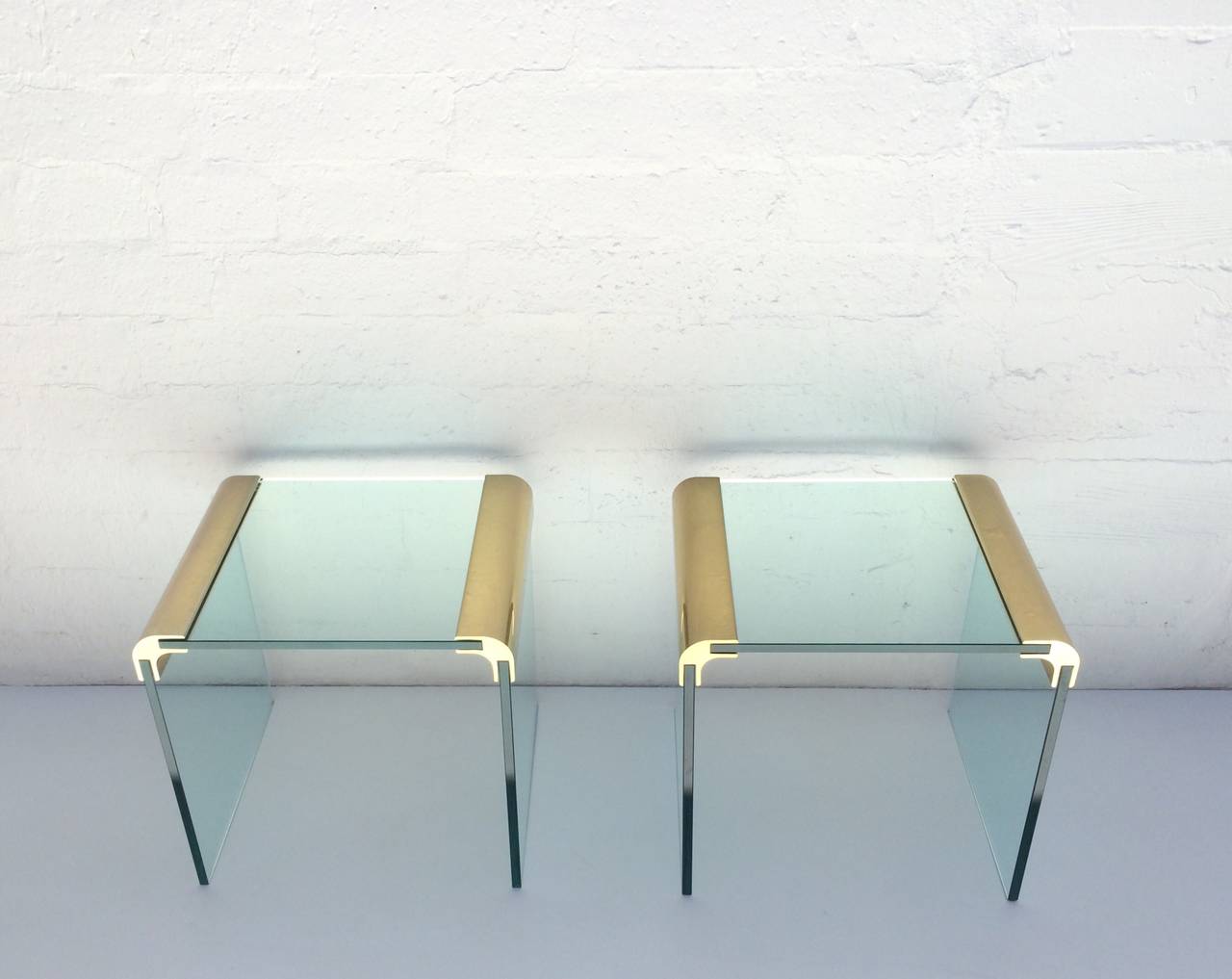 Pair of side tables by Pace Collection. 
These tables are in original condition without any scratches on the glass or brass. 
They consist of the polished brass end pieces that hold the 1/2