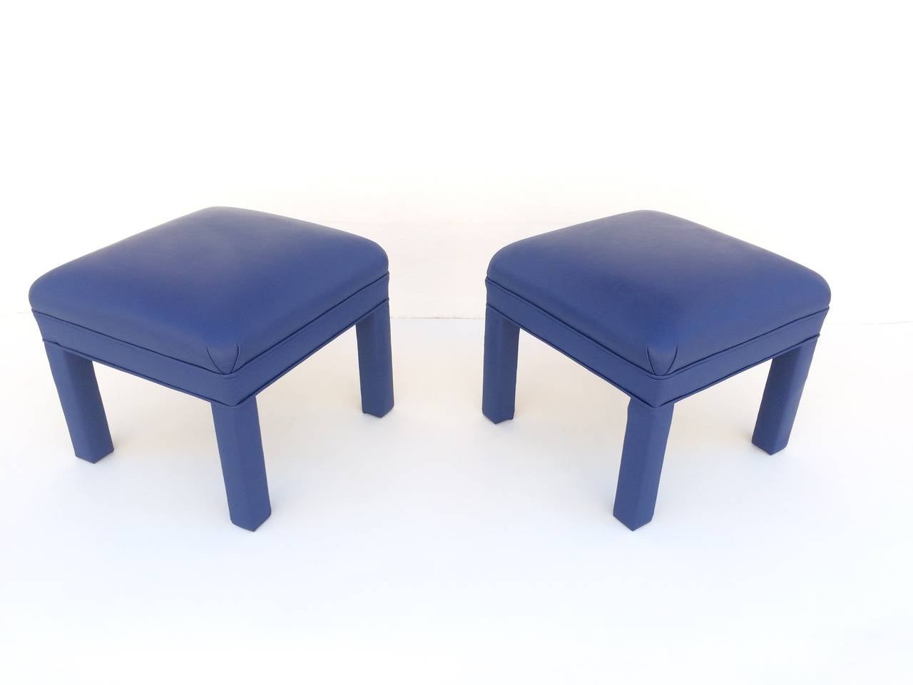 Pair of wood frame ottomans or small stools newly reupholster in a soft blue leather.